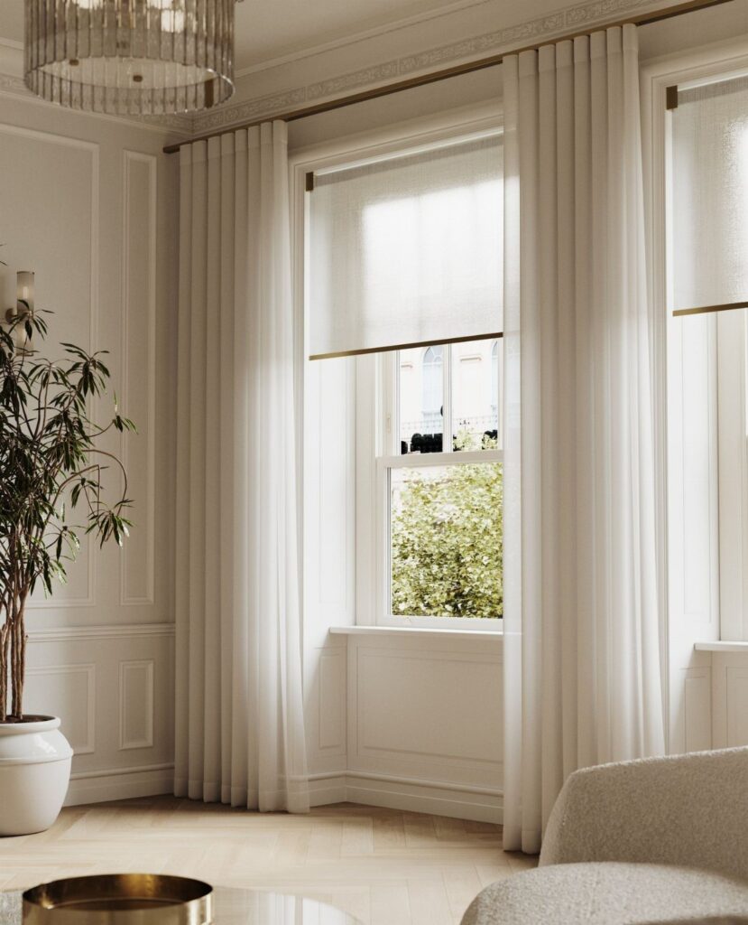 White curtains and a matching roller blind installed together on a bright window.