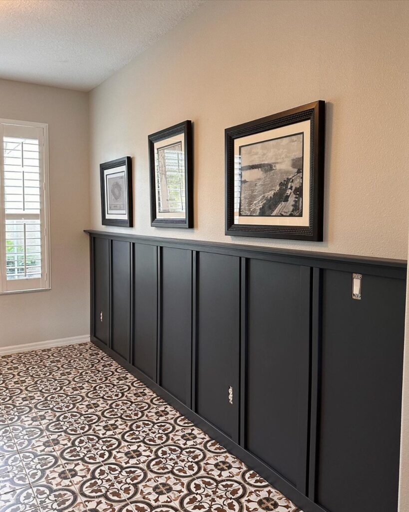 Dark grey board and batten wall paneling in a hallway with patterned tile floors.