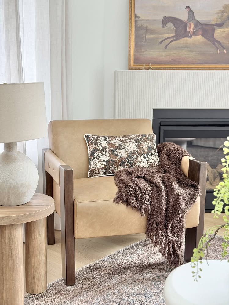 Tan armchair with brown faux-fur throw and floral pillow in a cozy living room