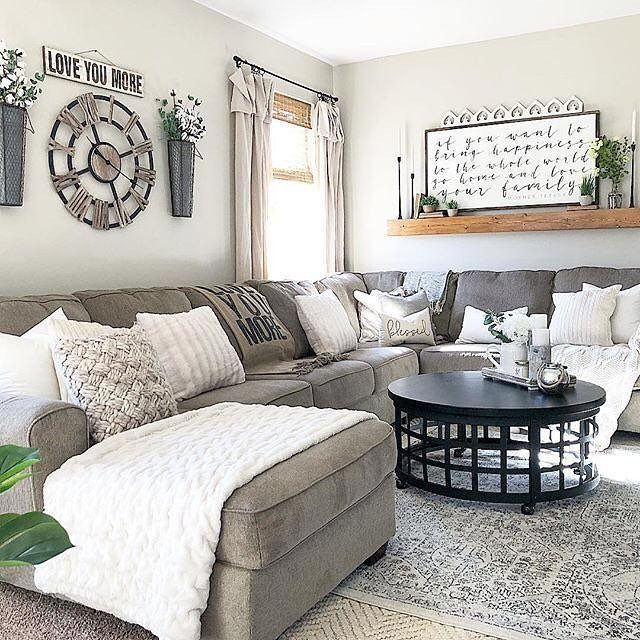 Living room with farmhouse modern wall decor, including a large wooden clock and signs.