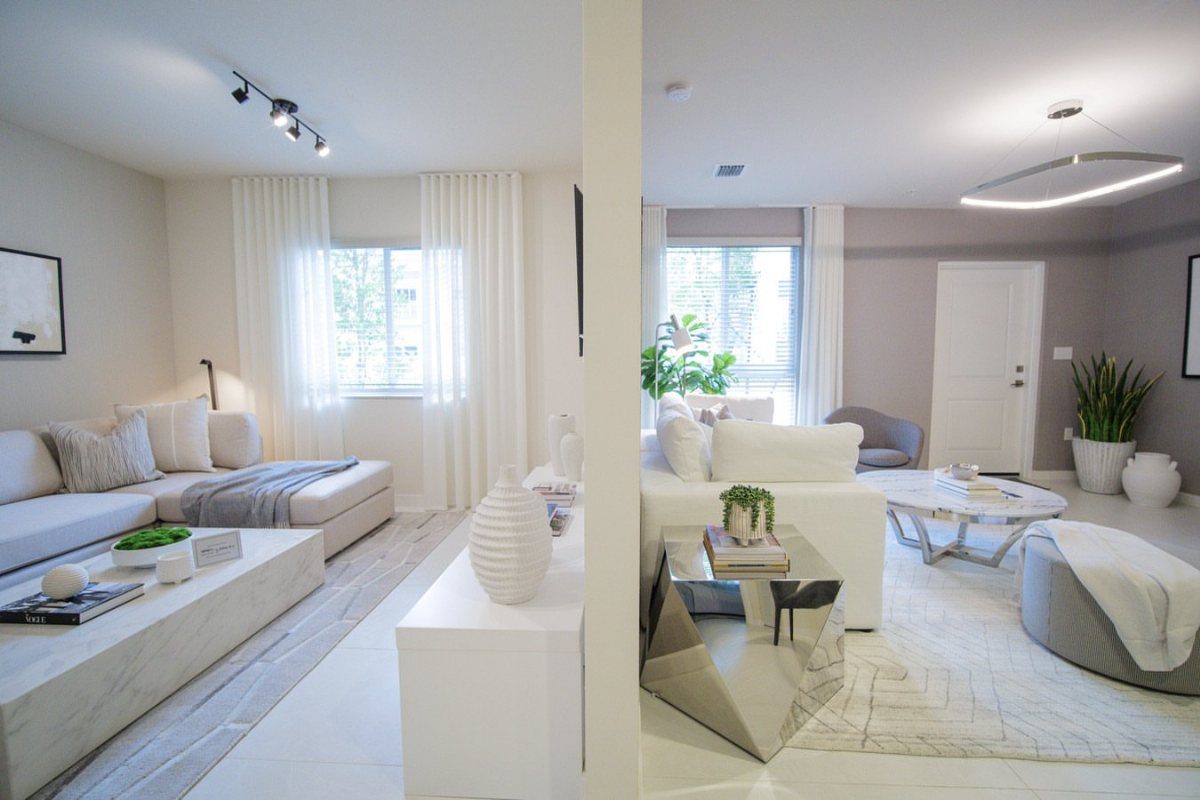 White sheer curtains hanging from ceiling to floor in a modern white apartment.