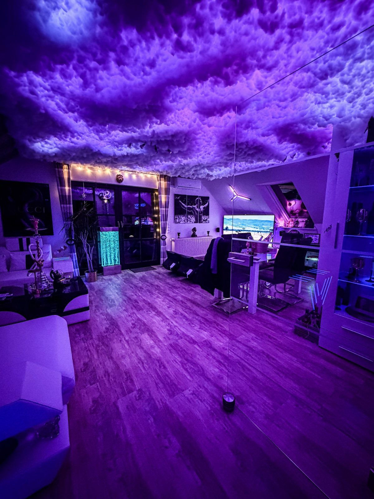 Purple cloud ceiling lighting in a modern gaming room with a computer desk.
