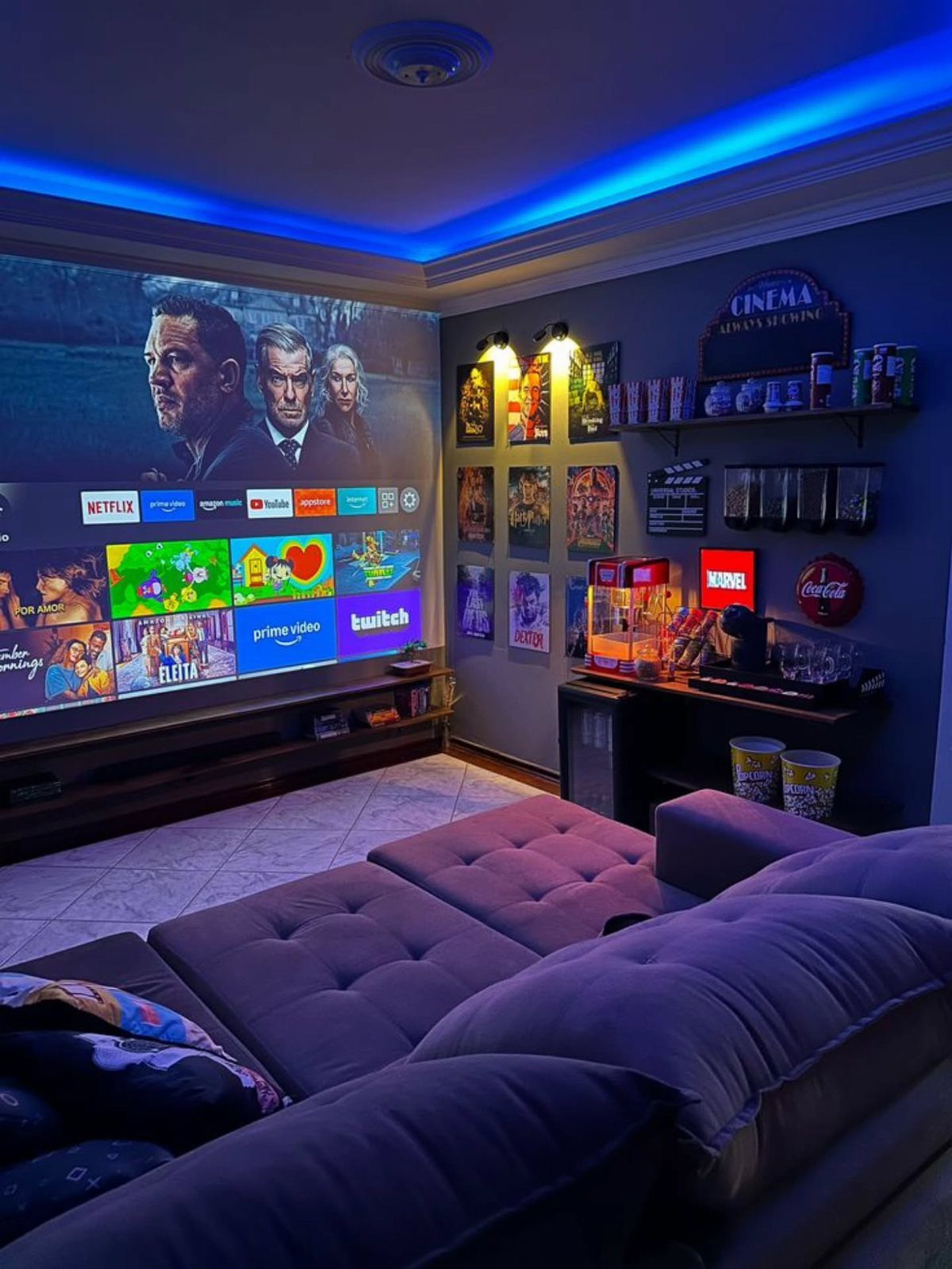 Home movie theater with large screen, purple sofa, and movie-themed wall decor.