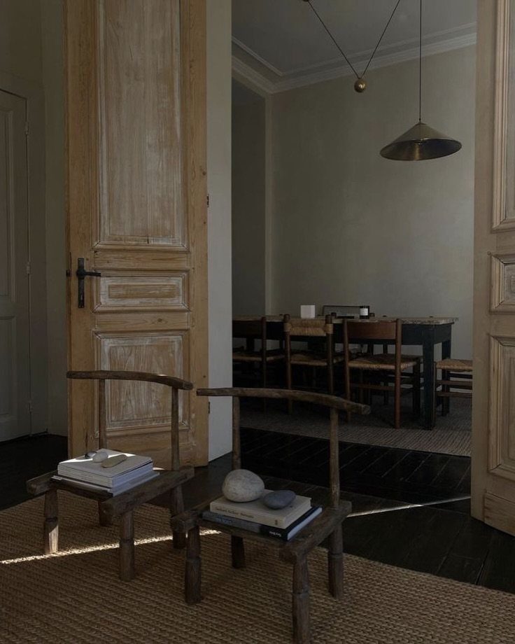 Rustic wooden chairs and weathered doors in a minimalist wabi sabi interior room
